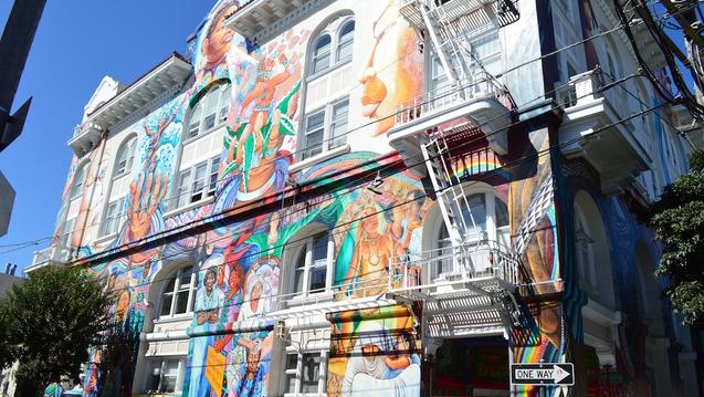 Looking up at a building with a colorful mural.