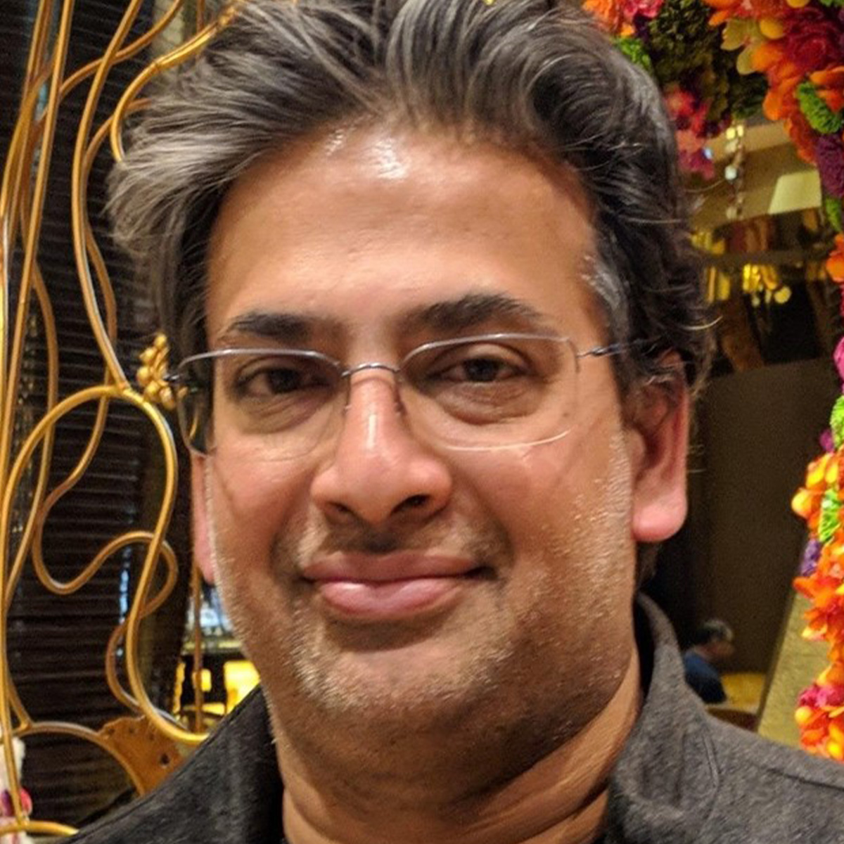 Srini Katragadda headshot. Srini is an older, Indian American man who is smiling and wearing glasses.