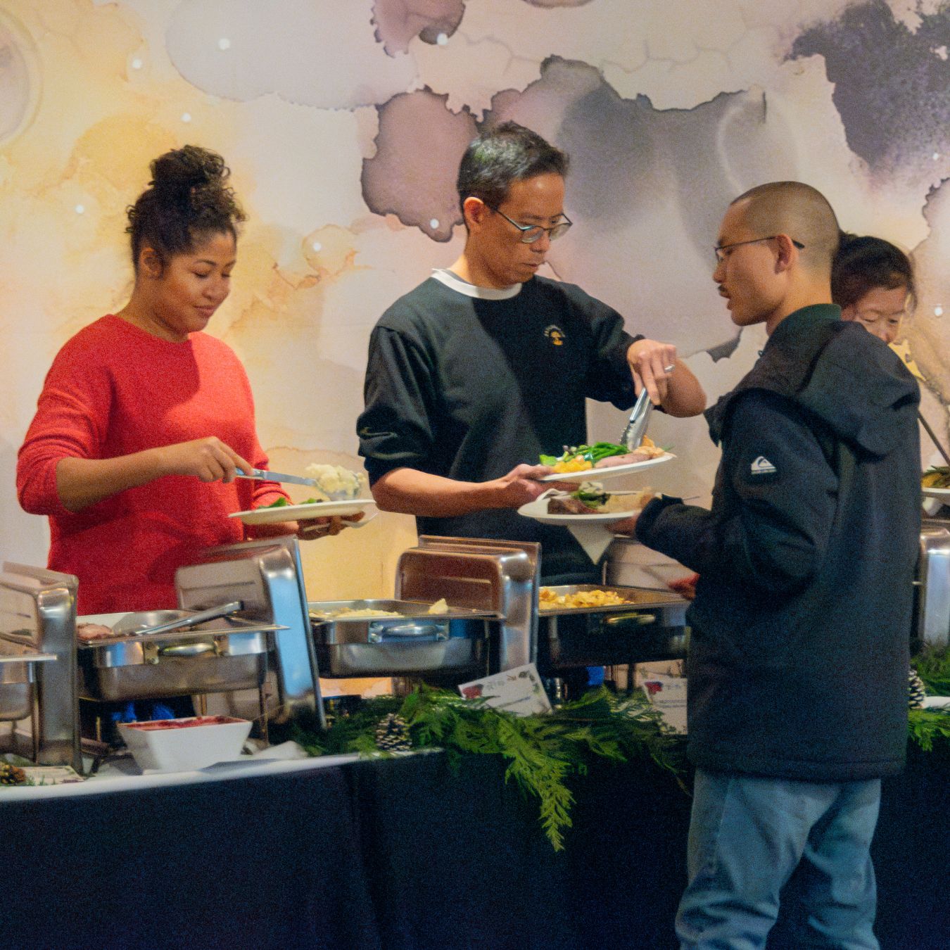 Four people serving themselves lunch 
