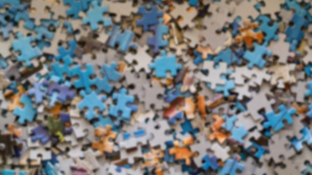 A lot of puzzle pieces laid out and in a pile