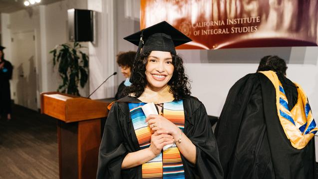 student graduating and holding diploma