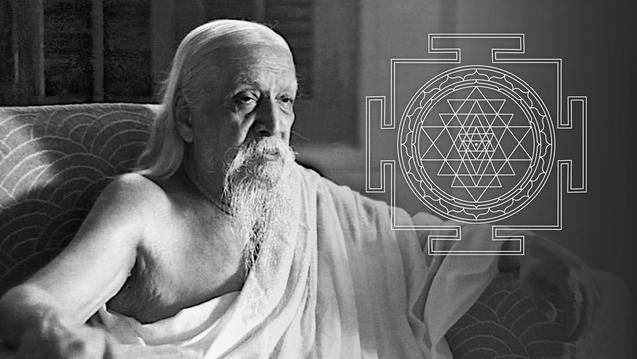 Black and white photo of Sri Aurobindo seated in an armchair. A white sri yantra symbol is laid over the top right of the photo.