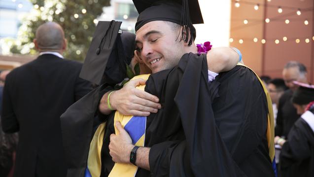 CIIS graduates hugging at Commencement