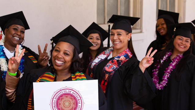 Photo of six women in graduation cap and gown