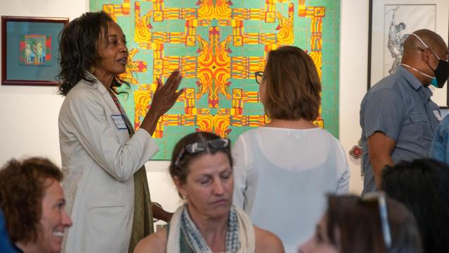 Photo of people talking in front of artwork