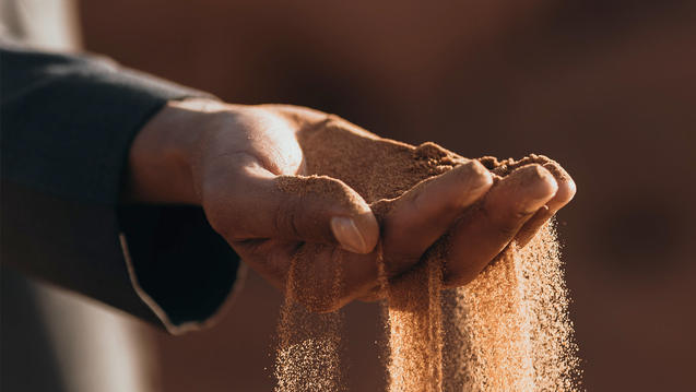 Photo of a hand with sand flowing between the fingers
