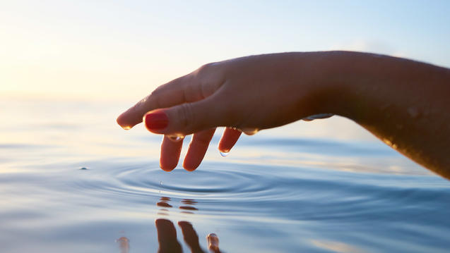 Hand touching water by Yoann Boyer