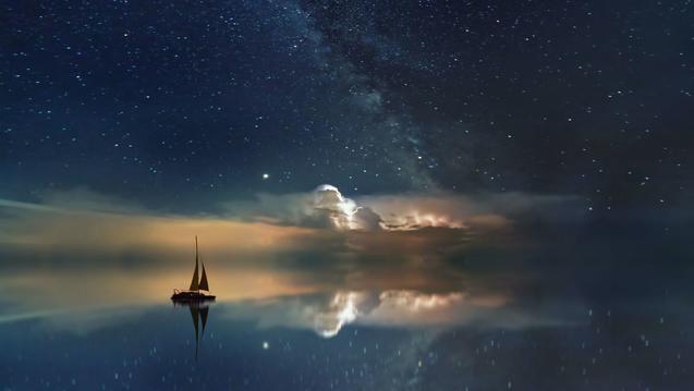 Image of a sailboat on a vast water reflecting the stars