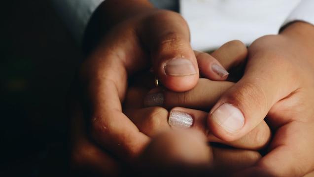 Hands of a person of color holding a woman's hands to symbolize equity and inclusion in integrated health at CIIS