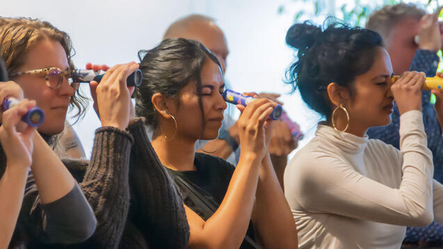 Photo of 3 people looking into kaleidoscopes