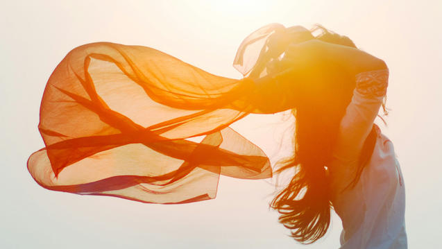 Peacock blue green duotone image of a woman dancing with a billowing sheer scarf
