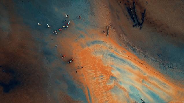 aerial of people standing in blue and orange land 