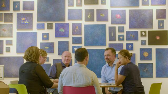 People sitting around table in front of gallery