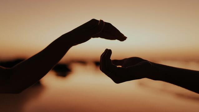 Two hands reaching out towards each other