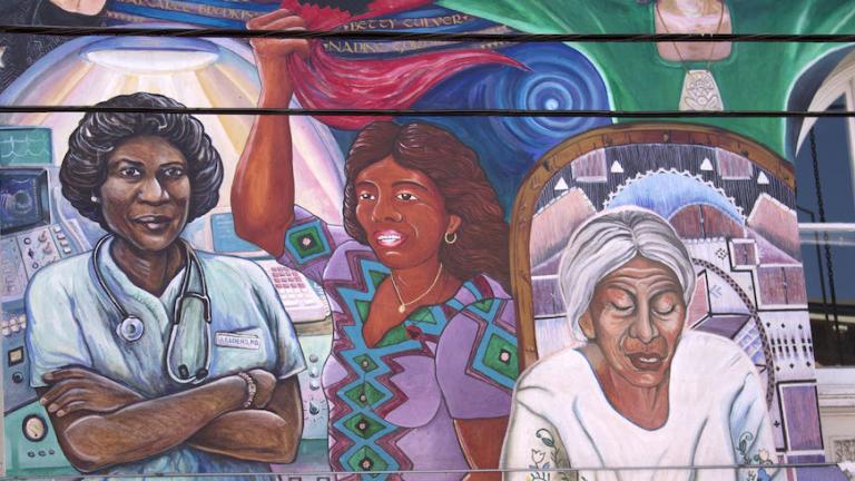 Mural with three women of colour: a medical doctor, a woman holding a red flag and an elder woman.