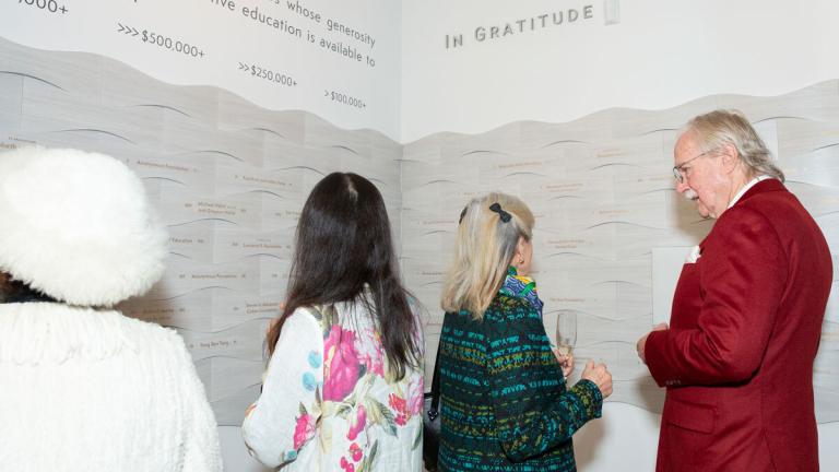 A photo of the people viewing the Donor Wall Art Installation by Alice Lin at CIIS in San Francisco.