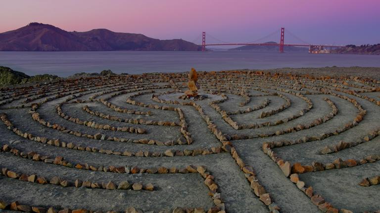 A labyrinth made of stones and rock on a beach shore