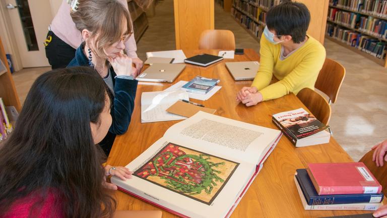 CIIS community looking at table of research materials