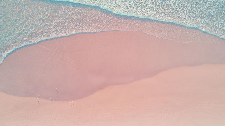 Photo of blue waves on a pink beach