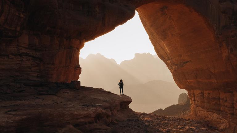 Standing in rock crack by Neom Pictures. 