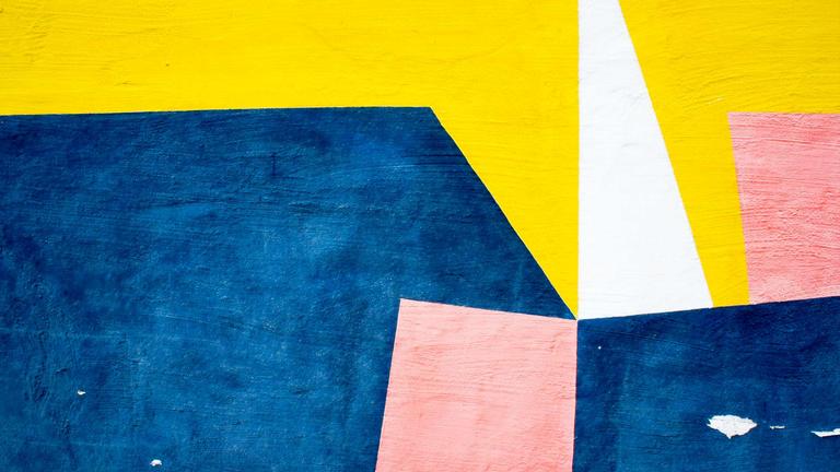 Abstract image of painted blue, yellow, pink and white geometric shapes. Original photo Boards on Unsplash.