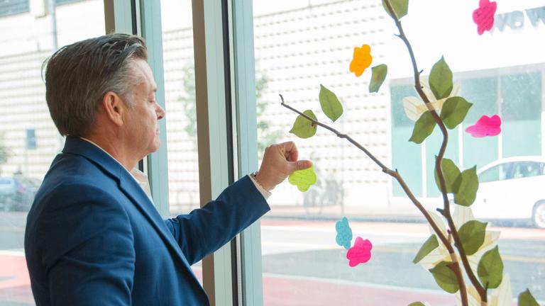 Photo of CIIS President S. Brock Blomberg adding a note to a window full of notes