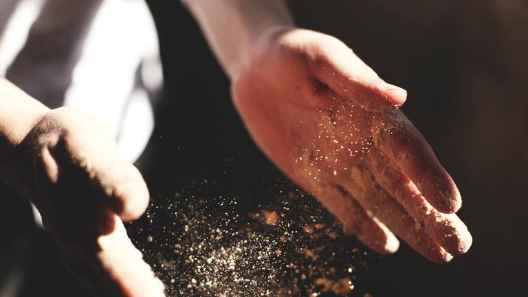 Close up of hands clapping dust