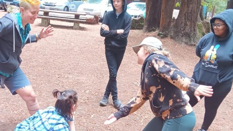 Five people playing an interactive game in an outdoor space