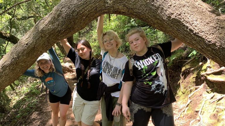 Four program participants posing under a tree