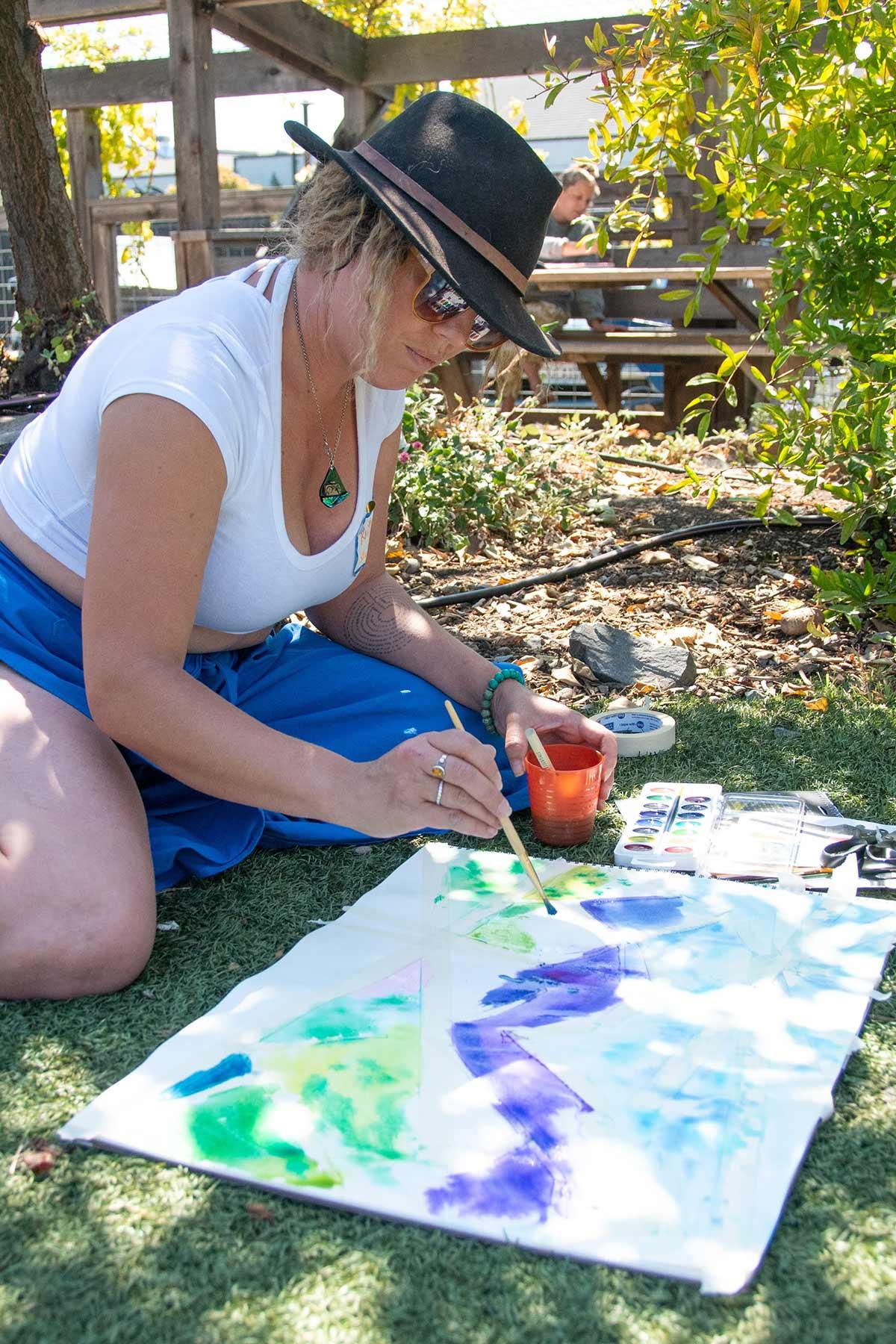 Photo of a woman sitting on grass and painting