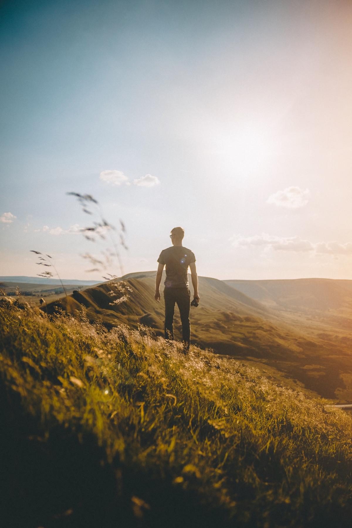 Person looking at rolling hills by Jose Llamas