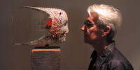 Eahr Joan, alumna of the Women's Spirituality program at CIIS, facing a sculpture.