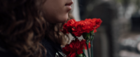 Person holding flowers grieving.