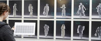 A woman observes gallery notes for the Chris Dorosz exhibition at CIIS in summer of 2022.