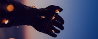 A stretched out hand wrapped in small lights