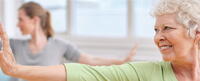 Photo of two people practicing yoga in Warrior 2 pose.