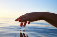 Hand touching water by Yoann Boyer