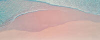 Photo of blue waves on a pink beach