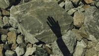Shadow of a hand on a stone