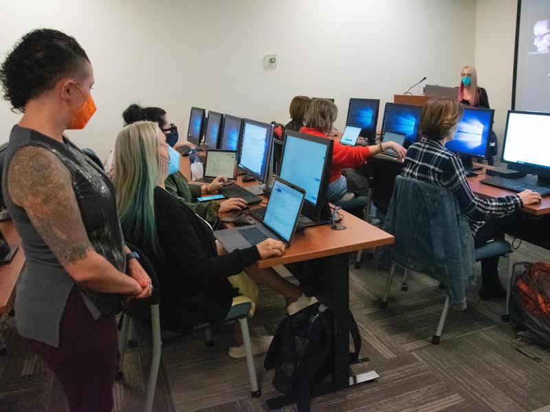 Photo of a class in session with students at rows of computer