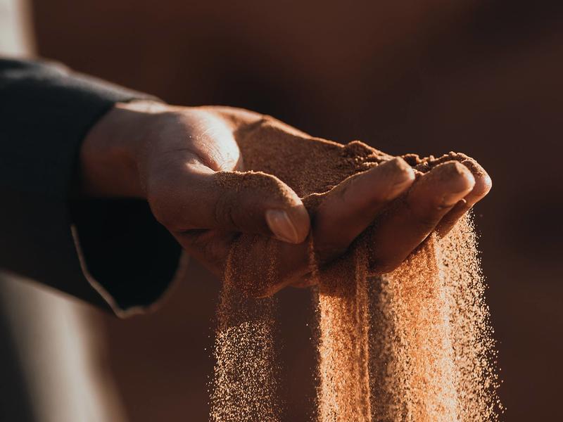 Photo of a hand with sand flowing between the fingers