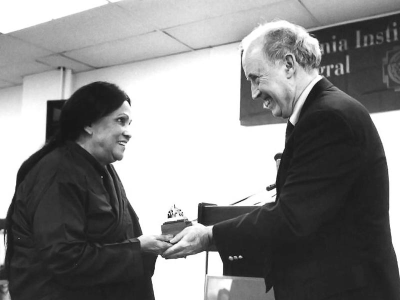 Photo of Rina Sircar and Robert McDermott standing with hands clasped and a small trophy between them